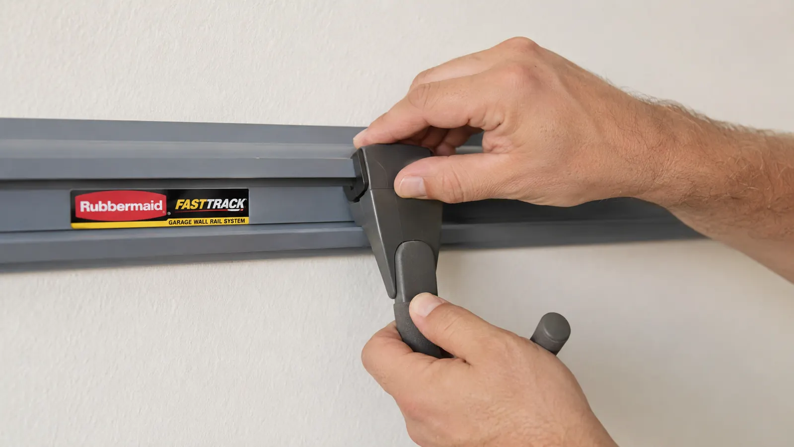 Close-up of a Rubbermaid FastTrack hook being pressed onto a wall rail, showing the locking mechanism at the base of the hook
