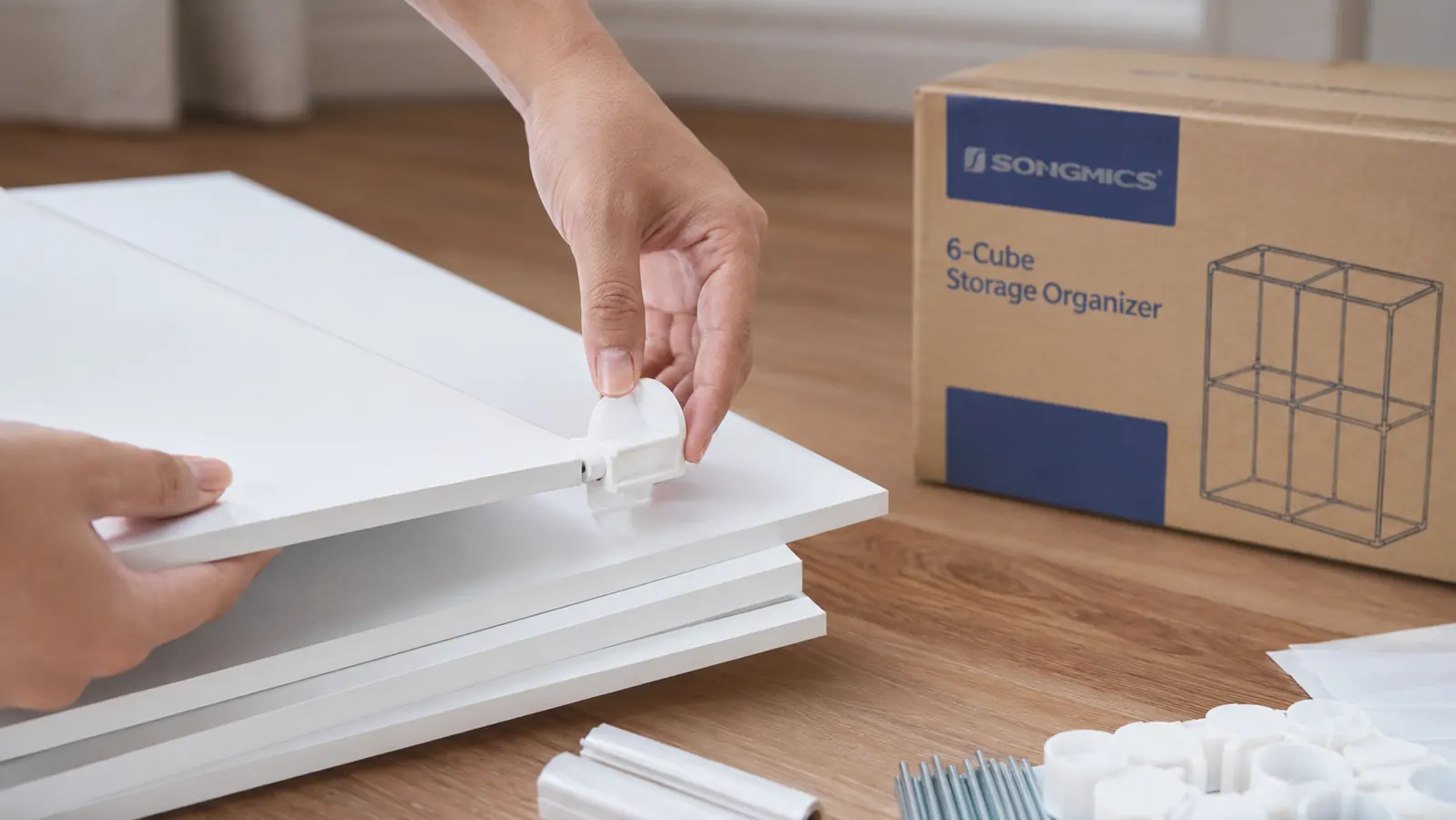 Close-up of SONGMICS cube connector clips being snapped onto a shelf panel during assembly
